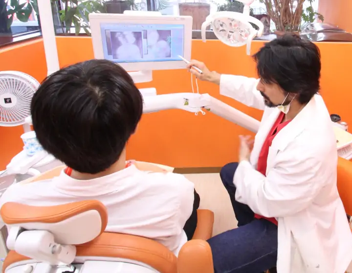 院長が患者にレントゲンを使用して説明する様子